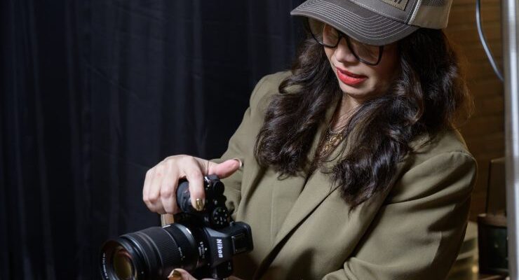 تصویر دوربین Nikon Z5 II در دست یک عکاس حرفه ای در حال عکاسی