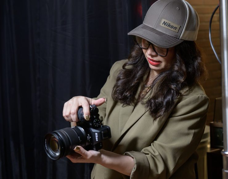 تصویر دوربین Nikon Z5 II در دست یک عکاس حرفه ای در حال عکاسی