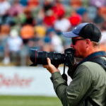 چگونه یک عکاس ورزشی حرفهای شویم | آموزش کامل عکاسی ورزشی از مبتدی تا حرفهای 9 عکاس ورزشی در کنار زمین فوتبال در حال تمرکز بر جریان بازی برای پیشبینی لحظه حساس گل.