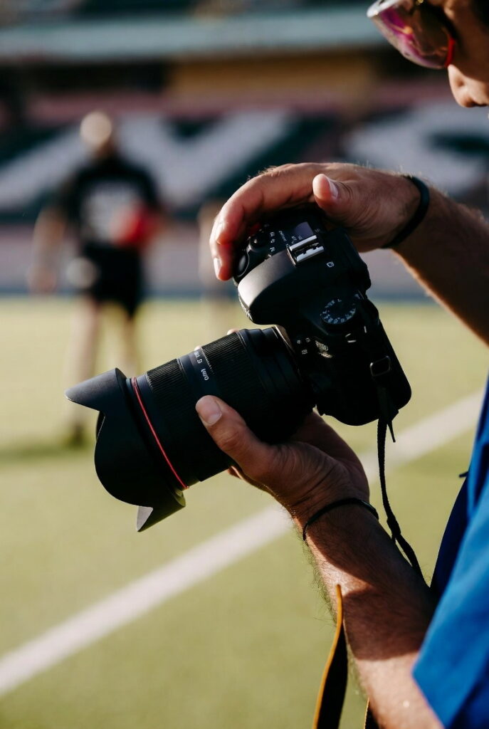 چگونه یک عکاس ورزشی حرفهای شویم | آموزش کامل عکاسی ورزشی از مبتدی تا حرفهای 4 دوربین حرفهای با لنز تلهفوتو ۷۰–۲۰۰ میلیمتر روی مونوپاد کنار زمین مسابقه فوتبال.