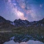 تصویری خیره‌کننده از کهکشان راه شیری بر فراز یک منظره کوهستانی در شب