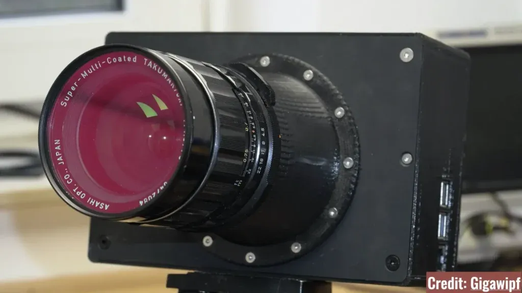 نمای نزدیک از یک لنز مدیوم فرمت قدیمی (مانند Pentax 67) که به بدنه سفارشی دوربین متصل شده است.