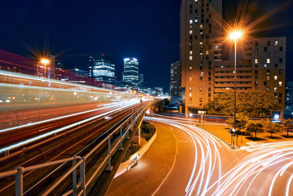 راهنمای جامع عکاسی شهری در سفر: تکنیکهای حرفهای برای تصاویری خیرهکننده 7 این یک تصویر است که در شب گرفته شده و نورهای درخشان را نشان میدهد