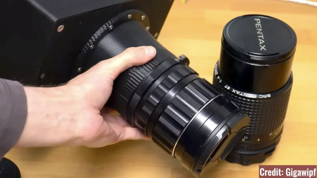 تصویری از یک تکنیسین متخصص در حال بررسی یک قطعه اپتیکال پیچیده در مرکز ایده‌آل دوربین.