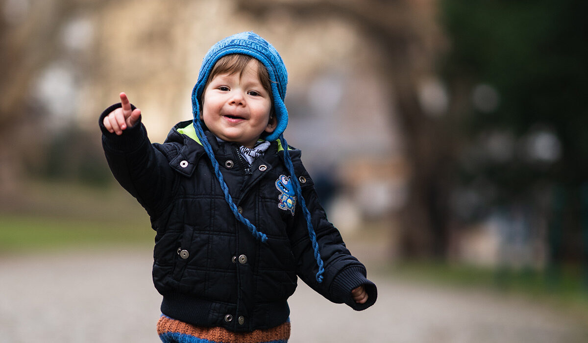 کودکی که در حال بازی در پارک است و به دوربین توجهی ندارد.