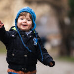 هنر عکاسی از خانواده: تکنیکهای حرفهای برای ثبت لحظات طبیعی و ماندگار 12 کودکی که در حال بازی در پارک است و به دوربین توجهی ندارد.