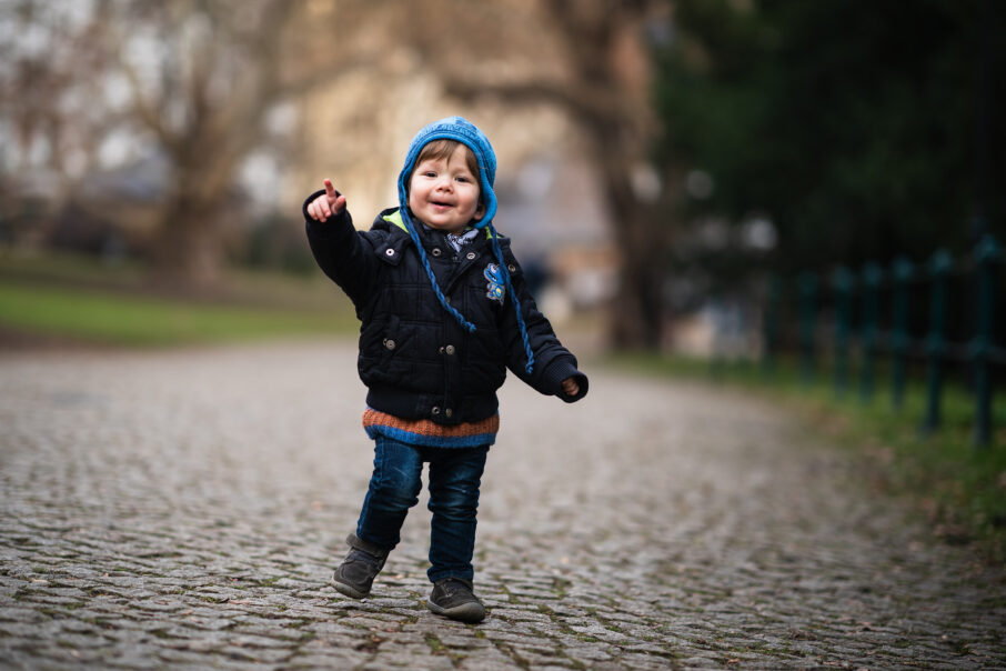 عکاسی که با زانو زدن و استفاده از نمایشگر چرخشی، از سطح دید کودک عکاسی می‌کند.