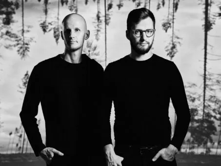 دو نفر در لباس سیاه که در کنار آب ایستاده‌اند