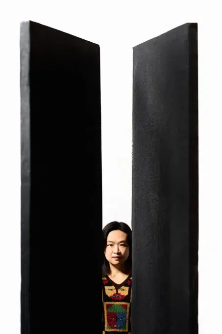 زنی که از میان دو سازه بزرگ عبور می‌کند