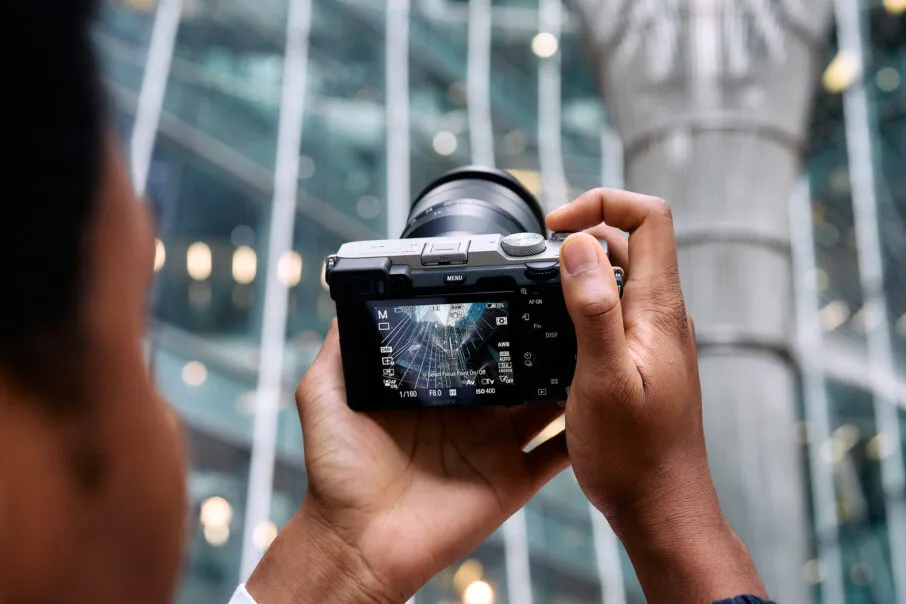 عکاس در حال عکاسی با دوربین سبک و قابل حمل در شهر