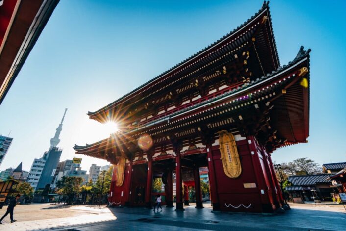 یک منظره شهری در لحظه غروب آفتاب که خورشید مستقیماً در لنز ایجاد لنز فلر و ستاره‌های نورانی کرده است