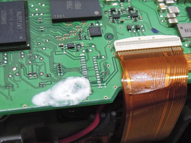 یک تکنسین تعمیرات در حال بررسی و تعمیر یک برد الکترونیکی دوربین با ابزارهای تخصصی